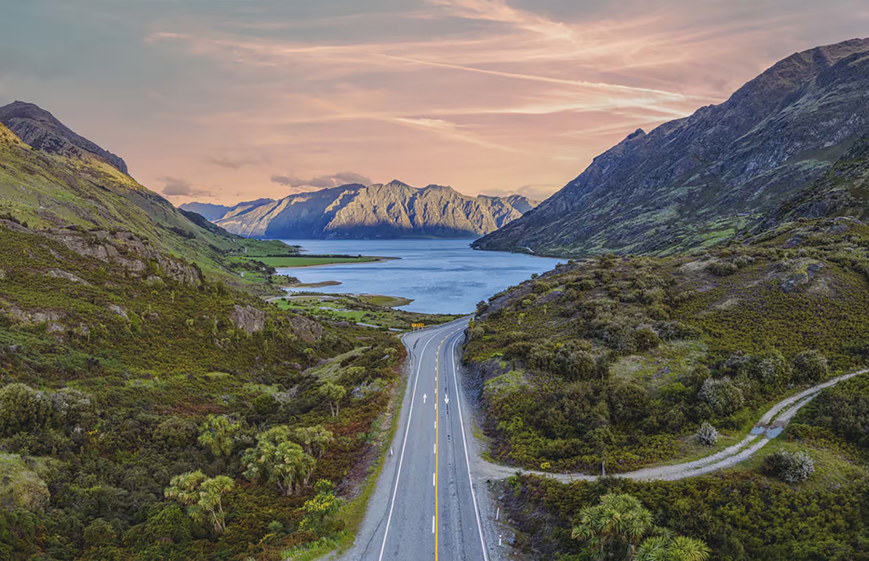 The hero image shows a photo of New Zealand green mountains and hills.