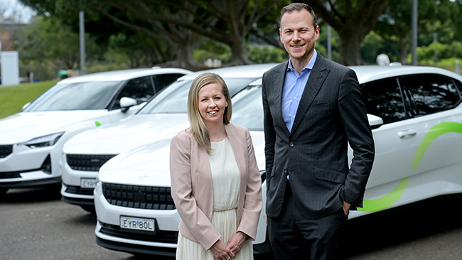 The hero image shows a photo of Lauren Lister and Christopher Tulloch from Custom Fleet standing in front of three white Custom Fleet branded EV with green markings.