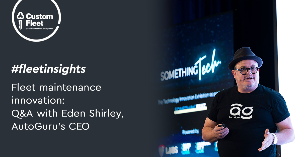 The image shows a photo of AutoGuru’s CEO, Eden Shirley, speaking at the Something Tech conference. Eden is wearing a black t-shirt with a white AutoGuru logo and a black hat.