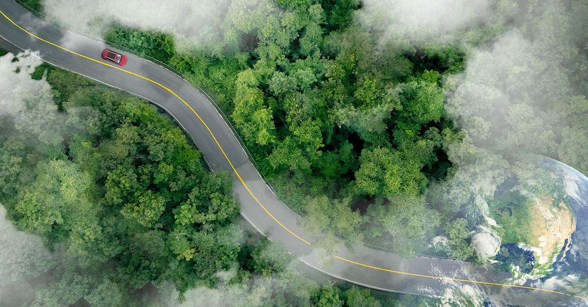 The hero image shows a red car in the top left corner on a winding road moving diagonally to the bottom right. The road is surrounded by trees and in the bottom right is the image of our planet earth.